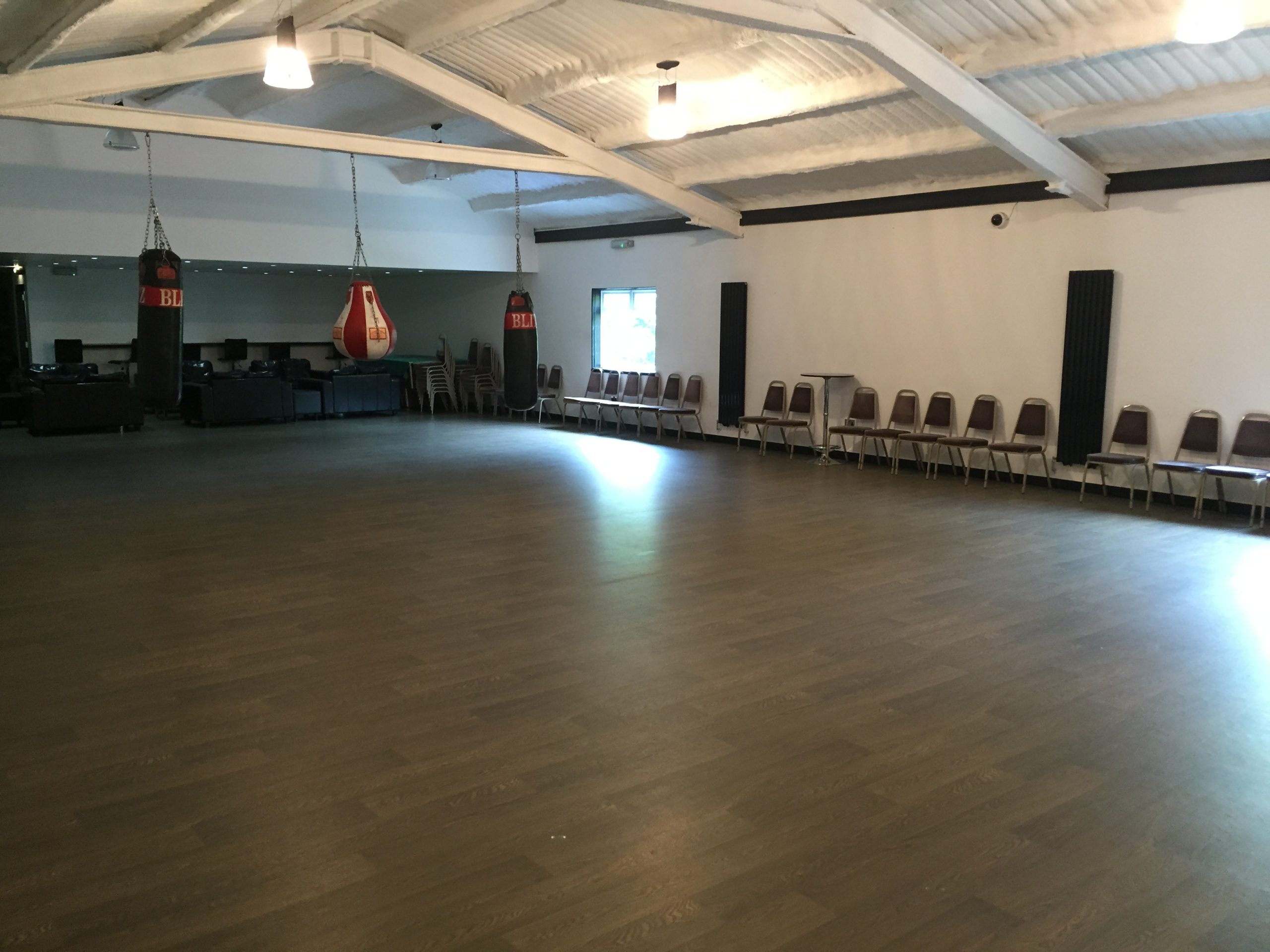 The empty hall at Venue 92 with a wooden floor, white walls and a high pitched ceiling.